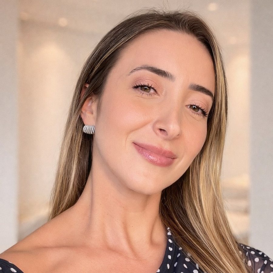 Retrato de Luana Peregrina sorrindo, com cabelo liso e brincos prateados